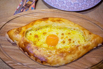 khachapuri in Adjarian style in a Georgian restaurant, top view