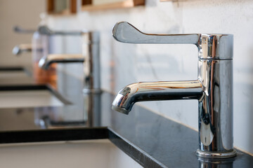 sleek chrome faucet installed on a polished black marble counter