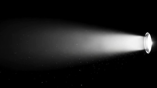 Single bright spotlight beam projecting light with dust particles visible, onto a dark, empty background.