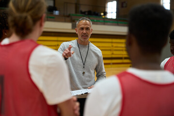 Basketball coach explaining strategy to team during timeout