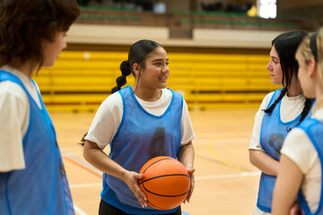Female basketball players discussing strategy during training session