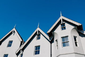 White houses with decorative gables reaching for the blue sky