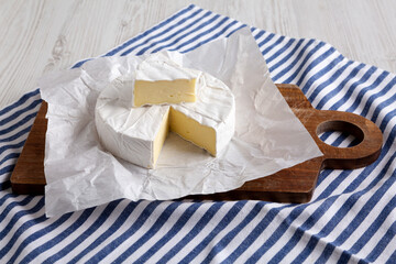 Homemade White Brie Cheese on a Wooden Board, side view.