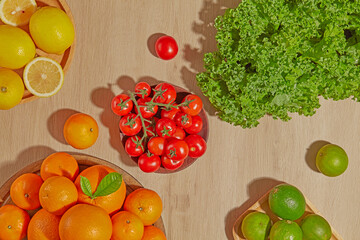 A composition of green kale, citrus fruits, and bell peppers lies on a beige wood surface. The color contrast enhances the organic, healthy food aesthetic.
