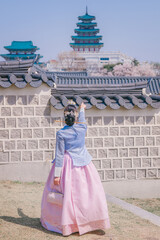 Young Woman in Hanbok at Gyeongbokgung Palace During Cherry Blossom Season, Seoul South Korea