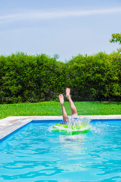 Mid adult man diving into a pool with a float on a sunny day in Argentina