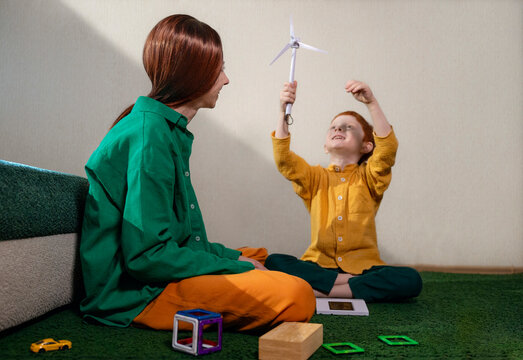 Mother and son playing with a wind turbine model at home