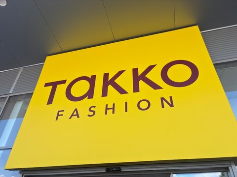Kitsse, Austria - 25 May 2025: Takko fashion store sign in yellow with red letters on a building exterior, concept of clothing retail, affordable fashion