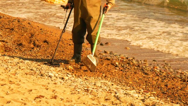 MetalDetector Beach Treasurehunting on shore with sand scoop, searching for lost items.