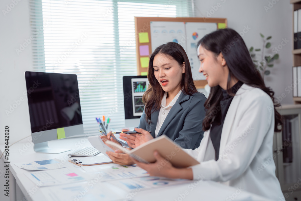 Poster two young businesswomen are working together in a modern office, discussing and analyzing financial 