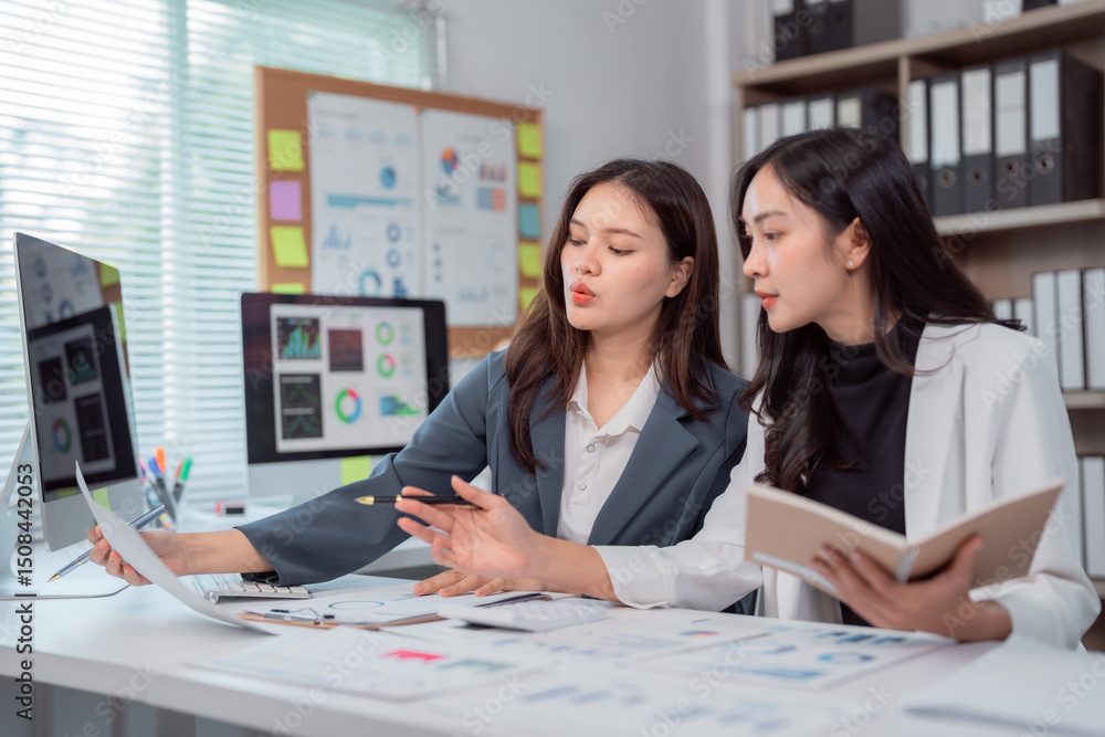 Aufkleber two young businesswomen are examining financial charts and discussing data in a modern office, colla