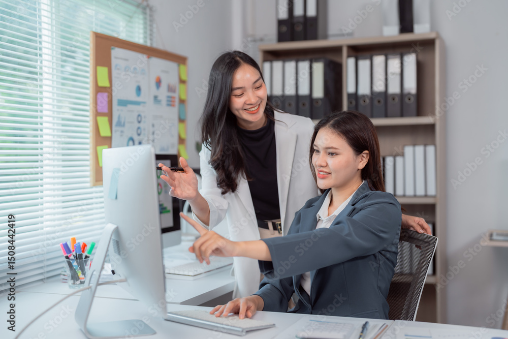 Aufkleber two asian businesswomen are collaborating on a project, using a desktop computer in a modern office,