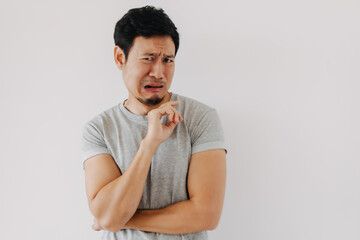 Asian man making disgusted face with curled lip and finger gesture