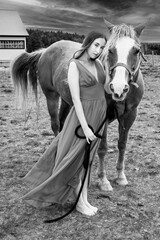 A young woman in a red dress with a horse