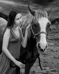 A young woman in a red dress with a horse