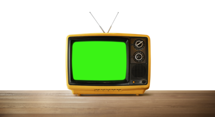 Old yellow television set with green screen showing on wooden table with transparent background