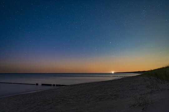 Wooden breakwater in the Baltic sea, peninsula Dar&szlig; or Darss, Mecklenburg Western Pomerania, Germany. Seascape at night. Long exposure photography. Blurred water. Night sky