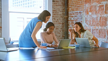Multi-Cultural Group Of Businesswomen Working Together In Boardroom