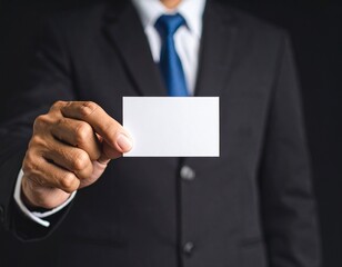 Office worker holding a horizontal business card, black background, strict business style, focus on hands and card.