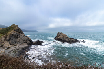 Waves crashing on rocks at gueirua beach in asturias, spain