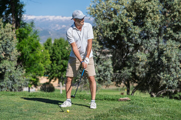 Golfer concentrating on perfecting swing on golf course
