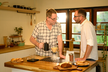 Mature father and adult son preparing fresh pour-over coffee in a cozy kitchen