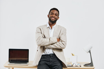 Confident young African American man with short hair and beard, wearing casual beige blazer and...