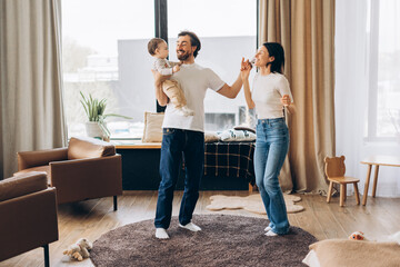 Happy family dancing together in living room, happy parent concept