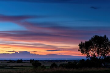 Sunset Over Fields And Silhouette Tree