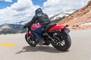 Obraz premium Riding a motorcycle on a beautiful winding road through lush green hills on a sunny day