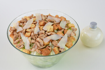 Classic Chicken Caesar Salad in a clear glass bowl with crisp lettuce, tender grilled chicken pieces, croutons, and Parmesan cheese side view of refreshing salad