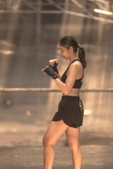 Vertical strong female Asian Muay Thai boxer practice Thai boxing 