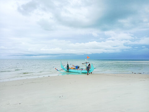 Fishermen working together to bring the boat to the sea at Serdang Beach, Manggar, East Belitung, Indonesia.