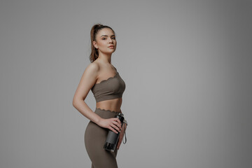 Woman posing confidently in a fitness studio wearing stylish activewear during a workout session