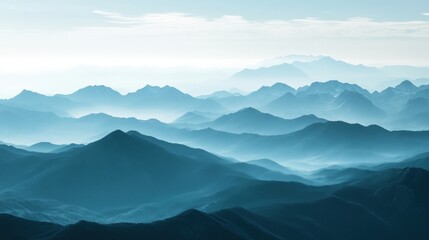 Misty mountain landscape at dawn with layers of peaks and valleys in soft blue hues