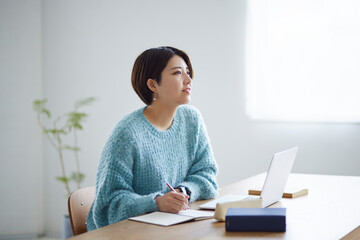 ノートパソコンで勉強をする若い日本人女性