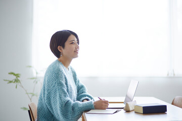 ノートパソコンで勉強をする若い日本人女性