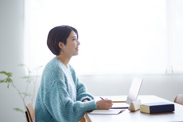 ノートパソコンで勉強をする若い日本人女性