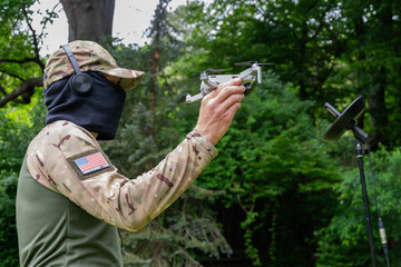 Fototapeta premium A military operator uses a drone and satellite communications for a tactical mission.