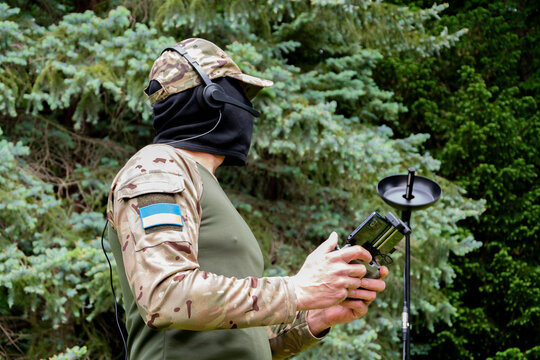A Ukrainian soldier in camouflage with a drone control panel and satellite communications in a wooded area. - Powered by Adobe