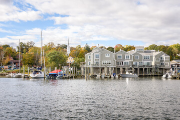 Waterfront apartments with private wooden jetties on a river on a partly cloudy autumn day
