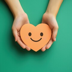 paper cut smiley face in hands make heart symbol for protection around on green background. positive thinking, mental health, assessment, world mental health day concept