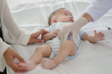 Doctors are gently vaccinating a boy in a clinic to ensure that the baby is healthy, protected and...