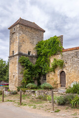 Fototapeta premium Ancient stone house with tower and climbing plants in Chateauneuf, Bourgogne Franche Comte, France