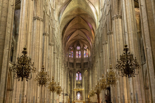 Interior of Bourges Cathedral showing stained glass windows and chandeliers
