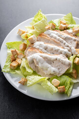 Classic Caesar Salad Fresh and crunchy Caesar salad on black slate background