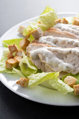 Classic Caesar Salad Fresh and crunchy Caesar salad on black slate background
