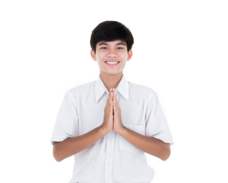 Young man in white shirt smiles warmly with his hands together in gesture of greeting or respect. His friendly expression conveys sense of joy and openness, set against plain background