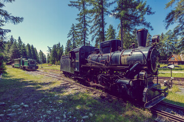 Old steam locomotive and diesel railcar standing on narrow gauge railway in Pribylina, Slovakia