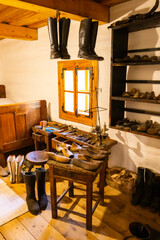 Old shoemaker workshop in Pribylina, Slovakia, displaying tools, lasts, and boots, preserving traditional craftsmanship